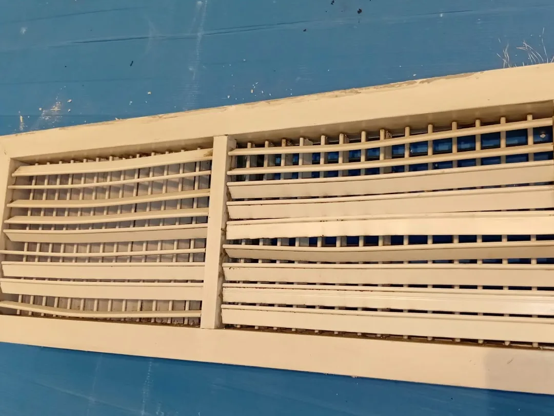After cleaning: the same ceiling grille, blades and gaps clear, photographed on the same visit.