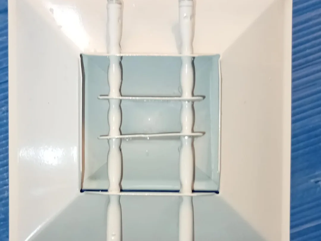 After cleaning: the same drain pan scrubbed, disinfected and rinsed back to white.