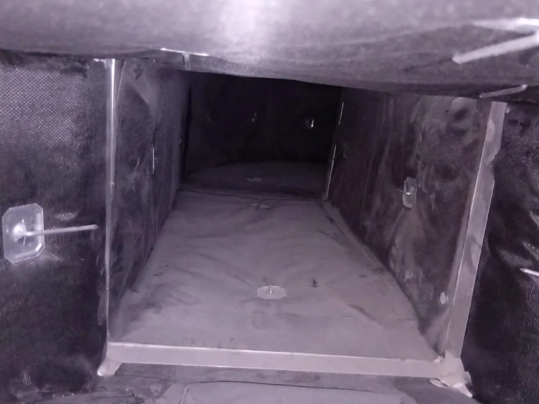 Before cleaning: the inside of an insulated supply duct, its lining furred with settled dust.