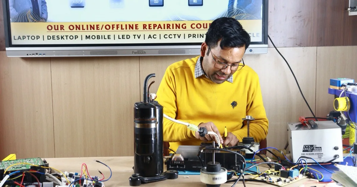 A technician repairs an air conditioner compressor unit on a workbench, with its copper refrigerant lines exposed.