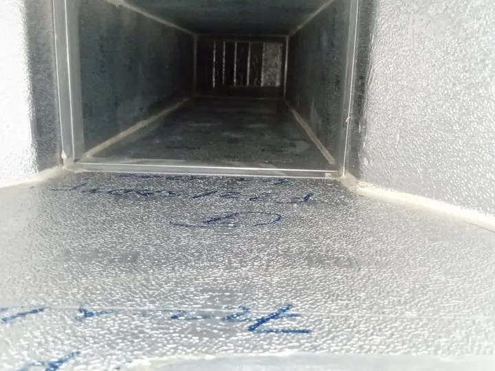 The inside of an AC supply duct after cleaning, its foil lining bright and clear of dust all the way down the run.