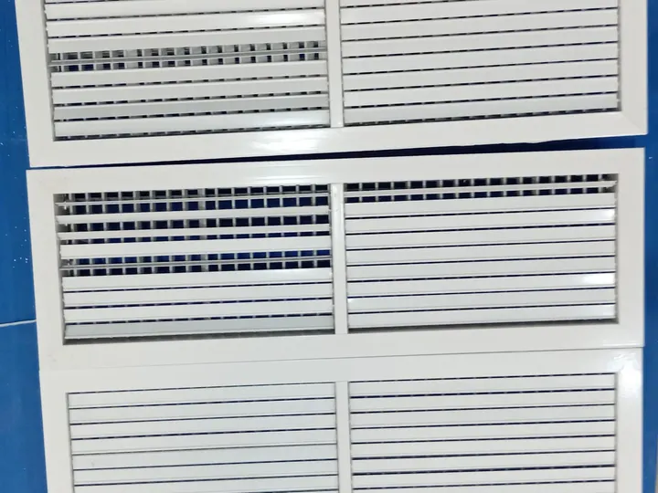 Three white AC grilles after cleaning and sanitising, their louvres spotless and free of mould.